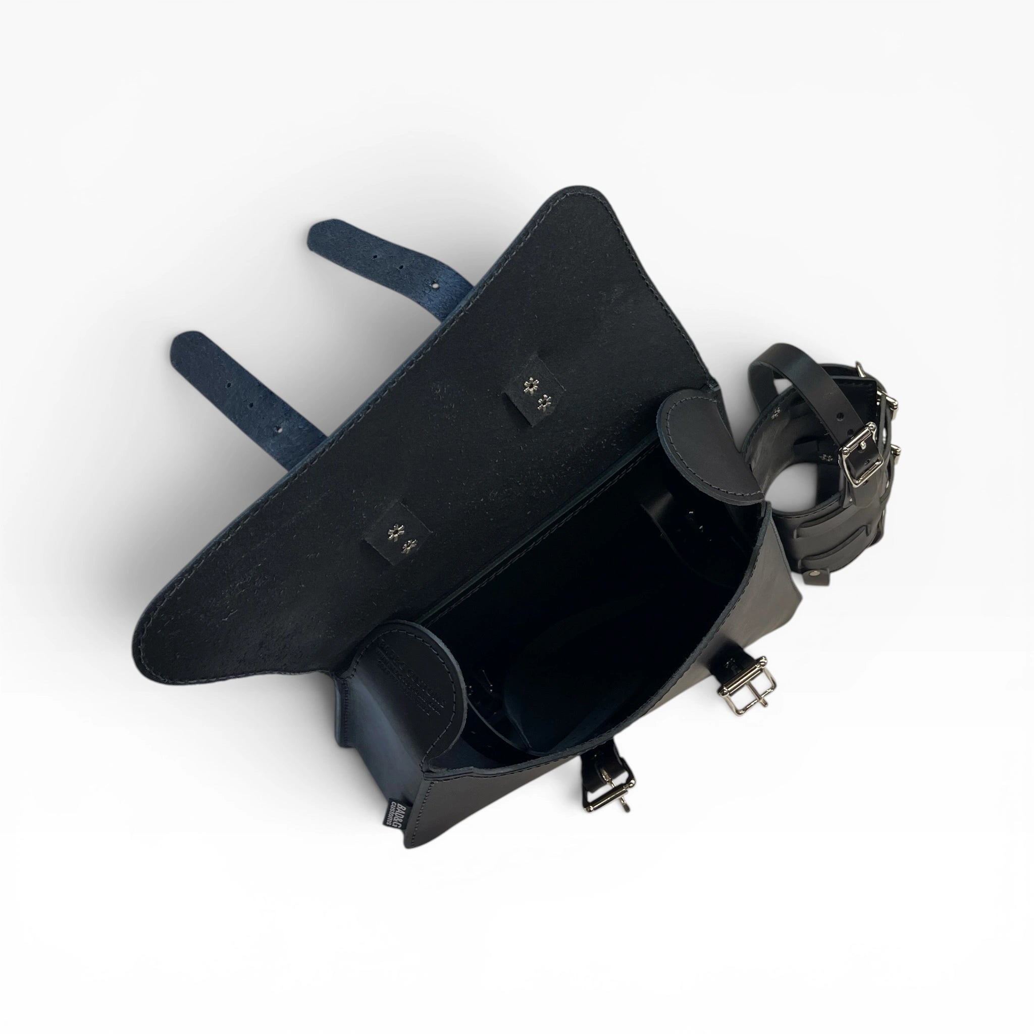 A black leather saddlebag shown from an overhead angle, featuring a dark blue leather strap and silver-tone metal buckles and hardware, set against a plain white background.