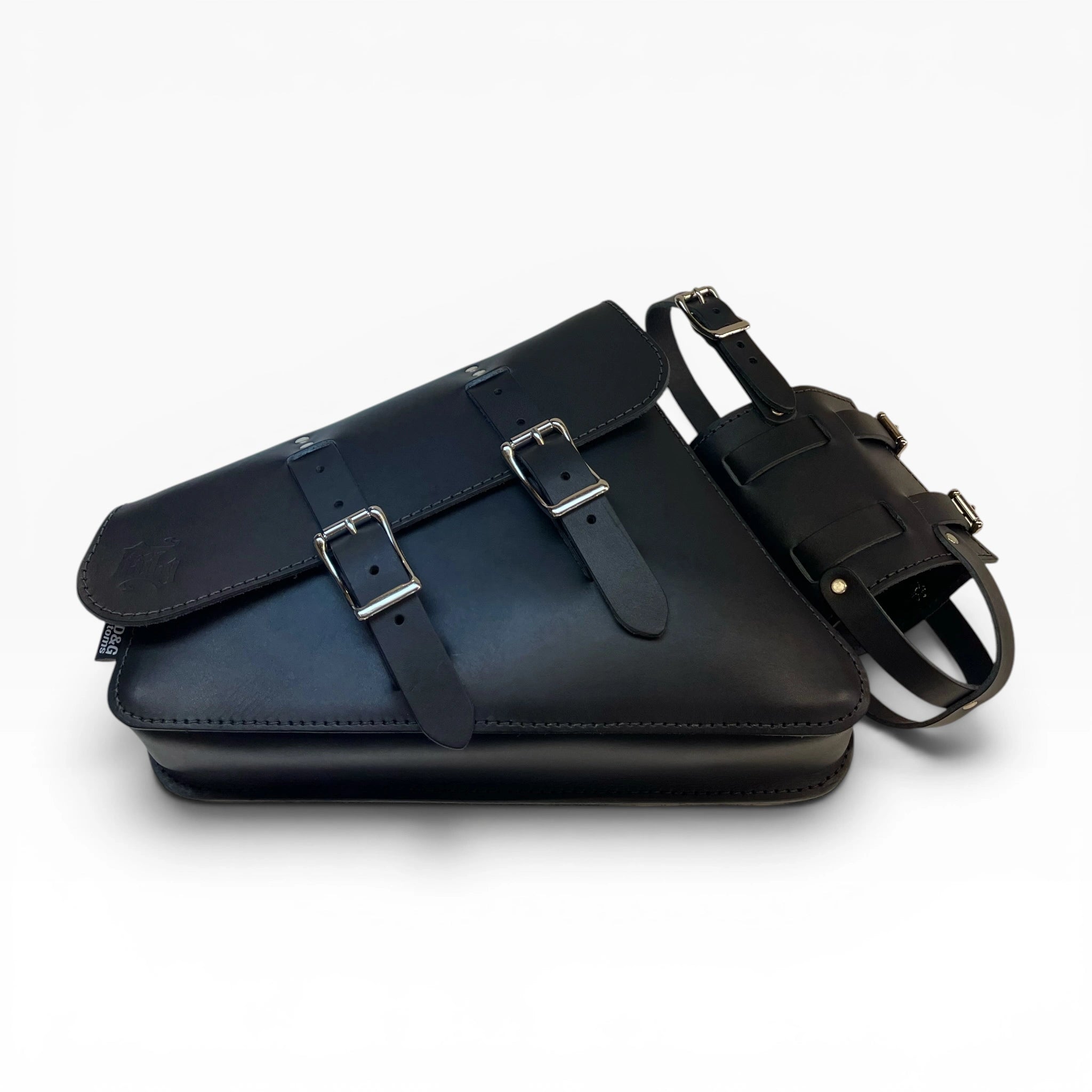 A black leather saddle bag with dual buckle straps on the front flap, shown alongside a matching black leather belt on a clean white background.